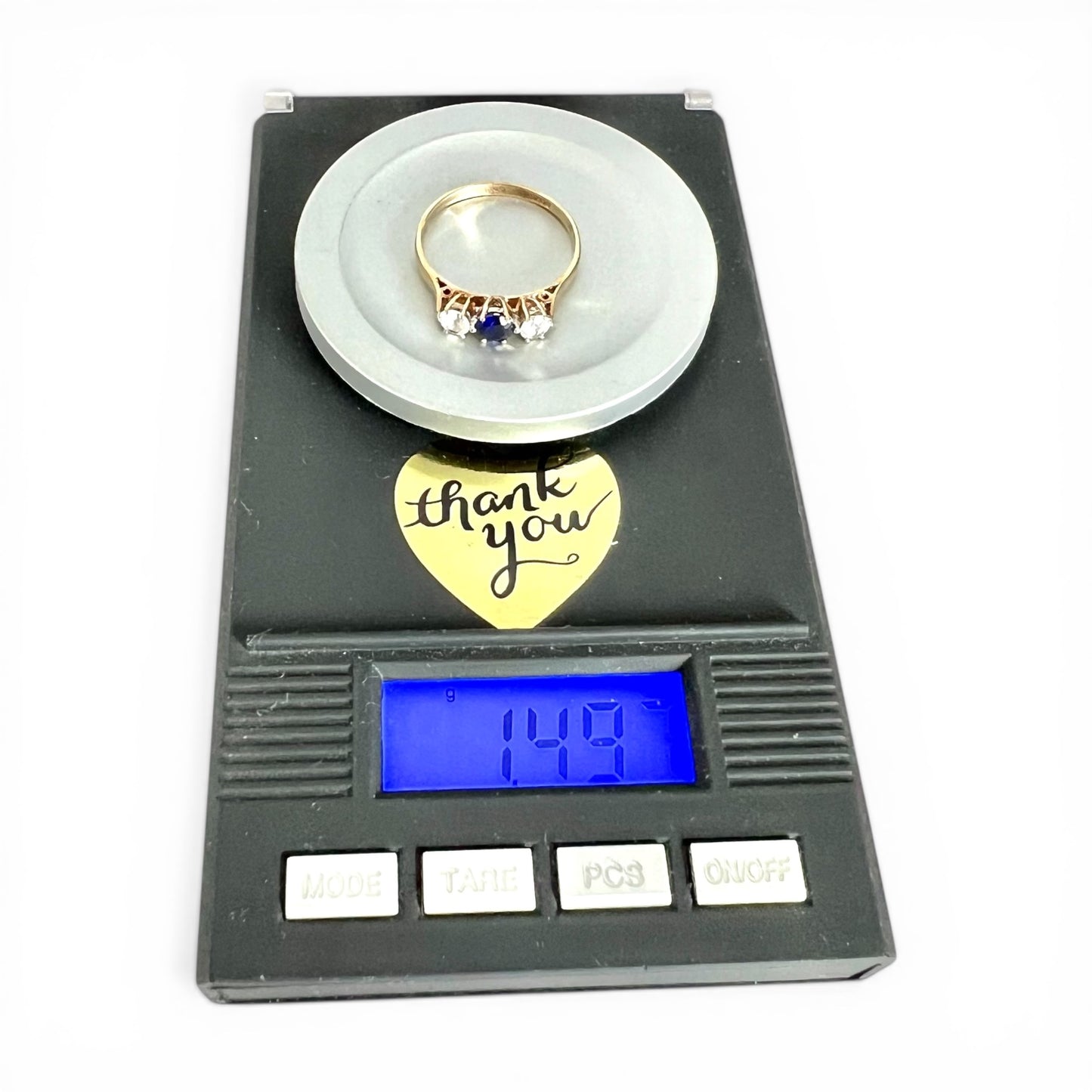 Gold ring on a digital scale with a 'thank you' note