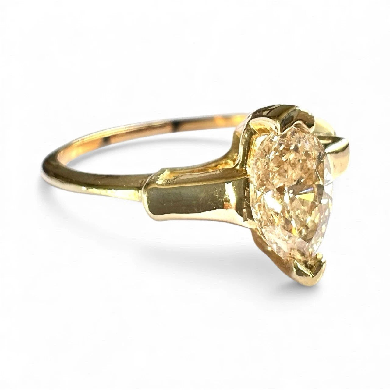 Gold ring with a large yellow diamond on a white background