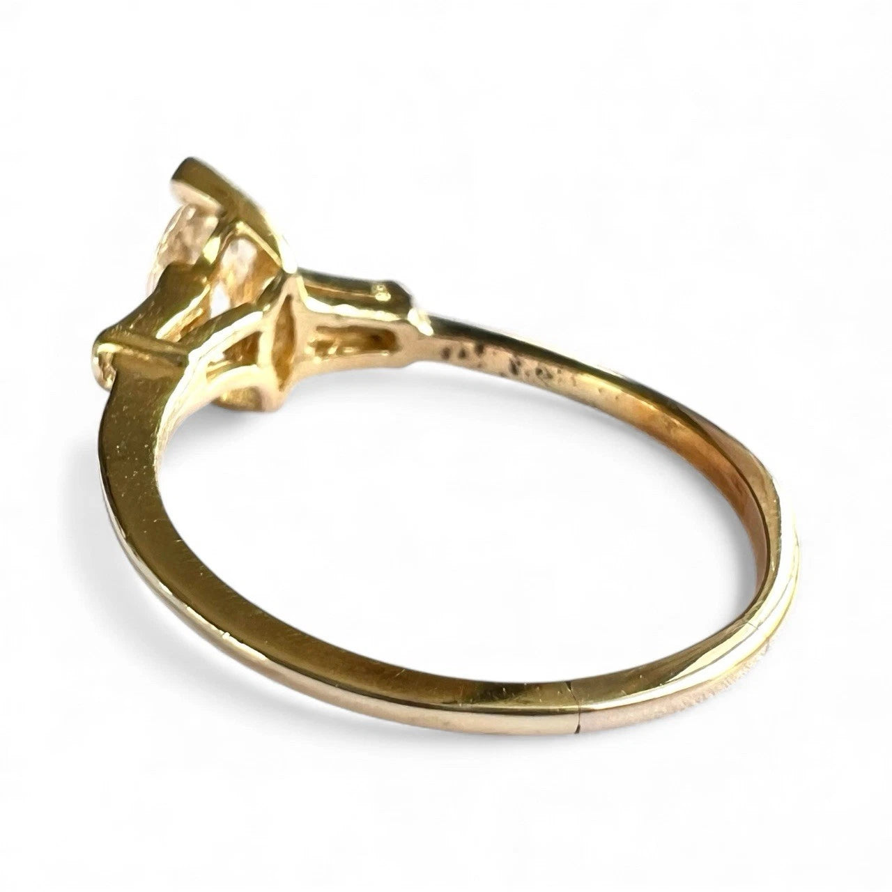 Gold ring with a tension set diamond on a white background