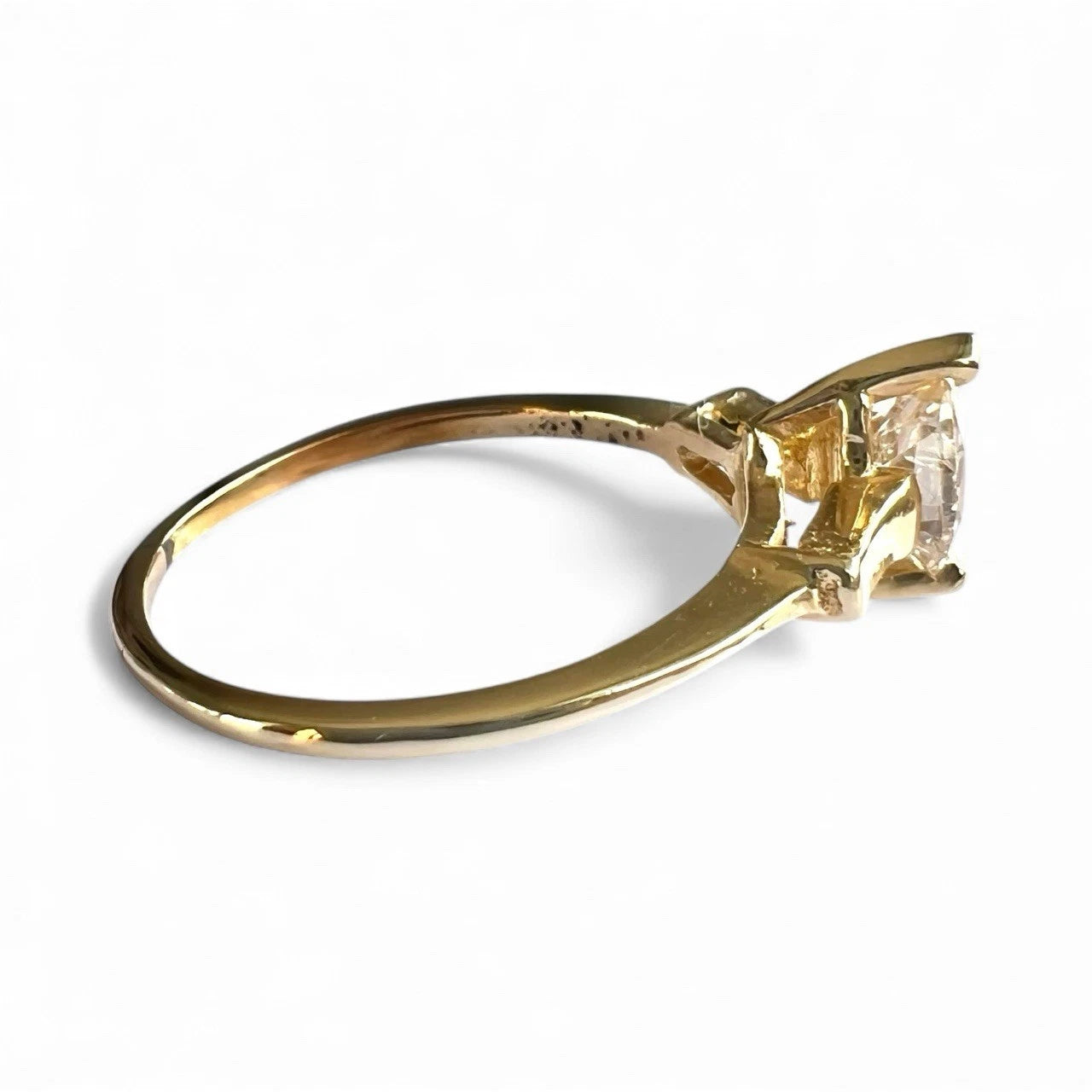 Gold ring with a large diamond on a white background