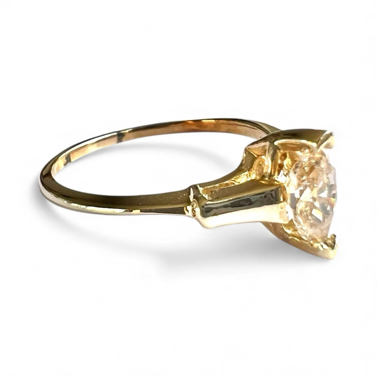 Gold ring with a tension-set large yellow diamond on a white background