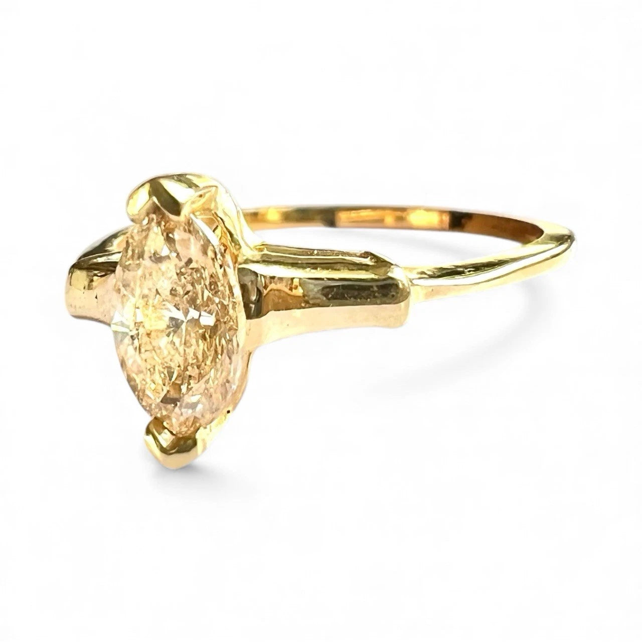 Gold ring with a large yellow diamond 
on a white background