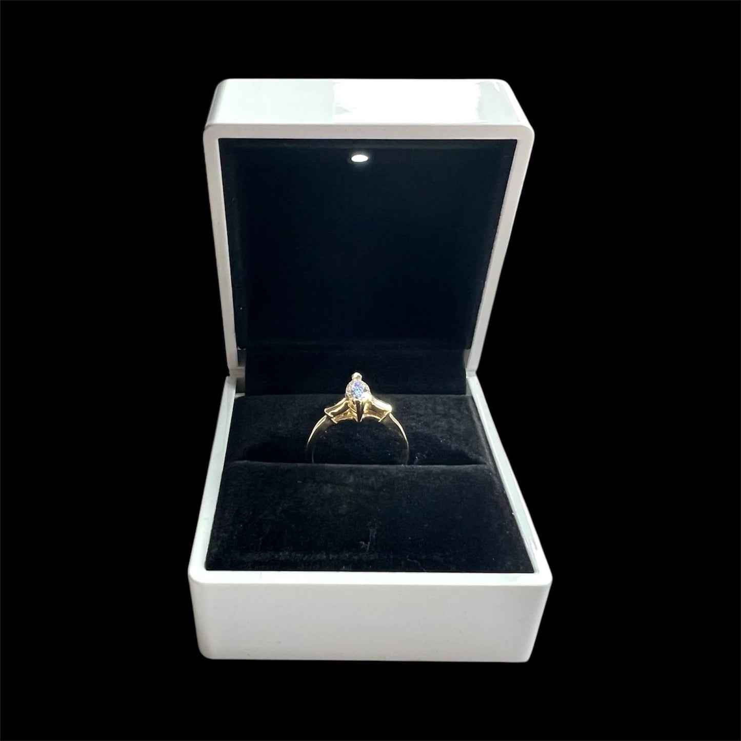 Gold yellow diamond ring in a white box with a black interior