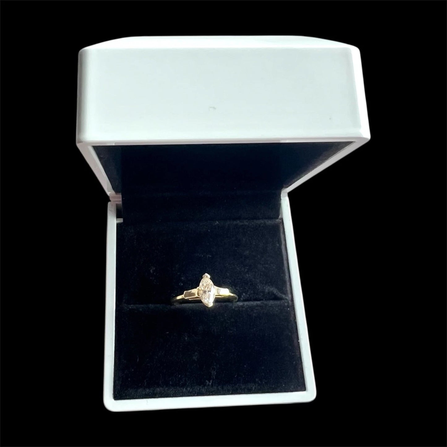 Gold yellow diamond ring in a jewellery box on a black background