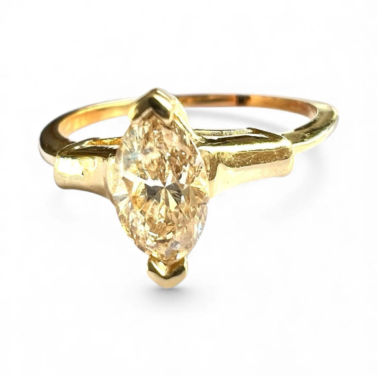 Gold ring with a tension-set large yellow diamond on a white background