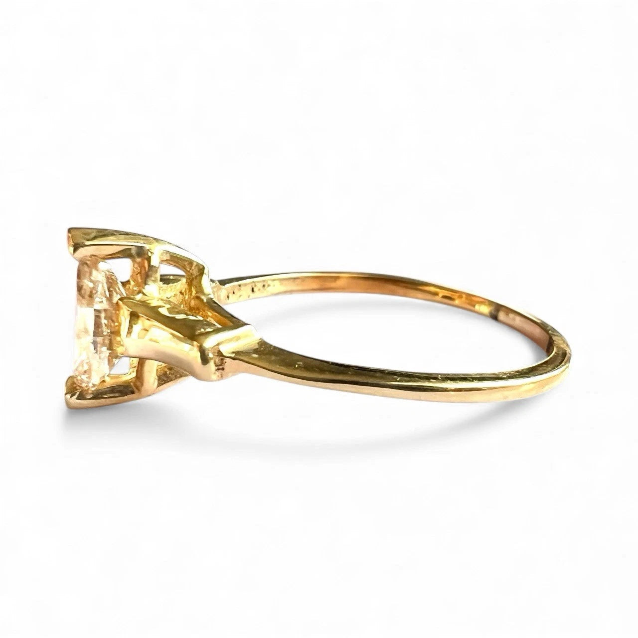 Gold ring with a large marquise cut yellow diamond on a white background
